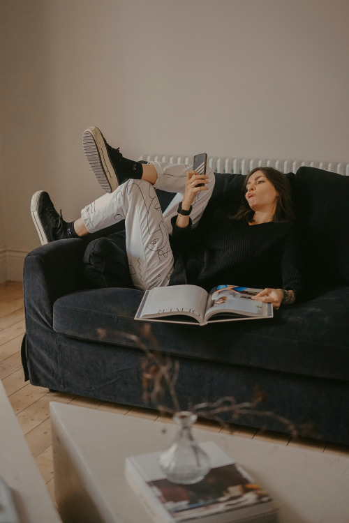 A woman lounging around, looking at her phone.